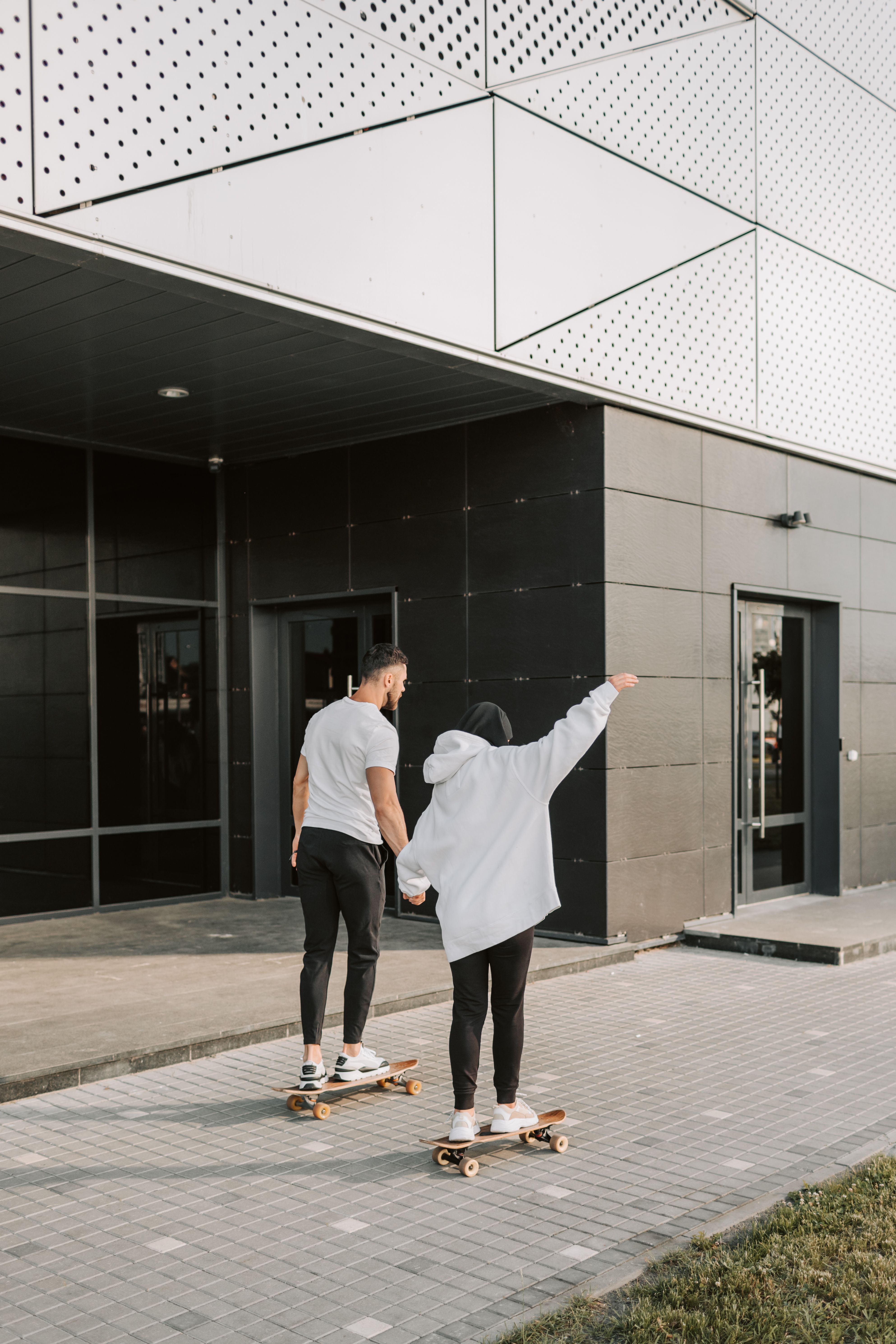 ليان ويوسف على ألواح تزلّج أمام مبنى حديث
